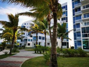 une rangée de palmiers devant un bâtiment dans l'établissement Coti’s house, à Río Hato