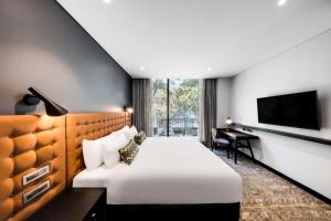 a hotel room with a bed and a television at Vibe Hotel North Sydney in Sydney