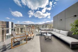 een woonkamer met een bank en stoelen op een balkon bij Vibe Hotel Hobart in Hobart