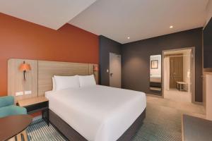 a bedroom with a large white bed and a desk at Travelodge Hotel Hurstville Sydney in Sydney