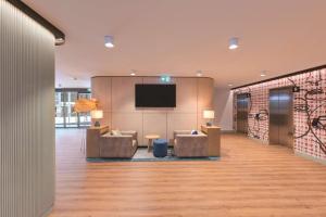 a lobby with couches and a flat screen tv at Travelodge Hotel Hurstville Sydney in Sydney