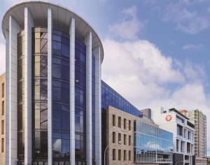 a tall glass building with a curved facade at Travelodge Hotel Hurstville Sydney in Sydney
