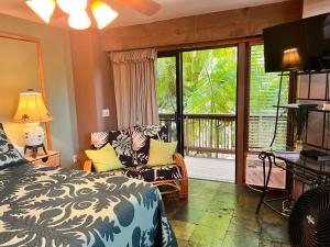 a bedroom with a bed and a sliding glass door at Maui What a Wonderful World Bed & Breakfast in Wailea