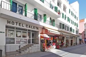 uma calaza de hotel está ao lado de um edifício em Hotel Caleta em Lloret de Mar