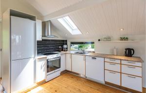 a kitchen with white cabinets and a white refrigerator at Lovely Home In Slagelse With House Sea View in Slagelse