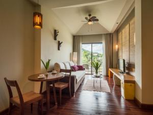 uma sala de estar com um sofá e uma mesa em Patravana Resort em Phayayen