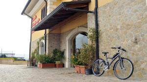 uma bicicleta estacionada em frente a um edifício em La Locanda del Buon Formaggio em Tito