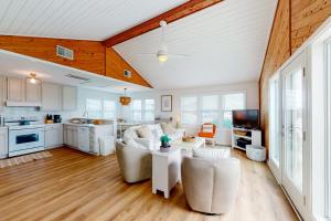 a living room with white furniture and a kitchen at Horizon House 405 in Frisco