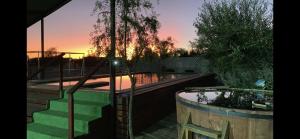 a swimming pool with a sunset in the background at Casa en Quillon 