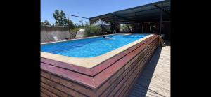 a large swimming pool with a wooden deck and a pool at Casa en Quillon 