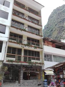 a tall building with plants on the balconies of it at Hotel Pucara Machupicchu in Machu Picchu