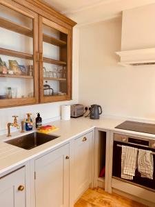 uma cozinha com armários brancos e um lavatório em Your Private Hoxton Apartment Sleeps 3 London Zone 1 em Londres