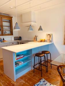 a kitchen with a blue island with two bar stools at Your Private Hoxton Apartment Sleeps 3 London Zone 1 in London