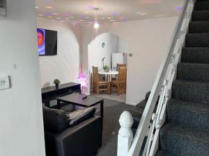 a living room with a staircase and a dining room at Adorable 2 bed house ideal for Family of Four in Manchester