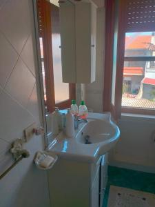 baño con lavabo, espejo y ventana en Appartamento Santa Giusta, en Santa Giusta