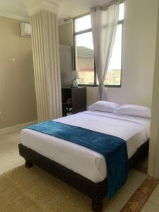 a bedroom with a large bed with a window at Reef Hostel Manta in Manta
