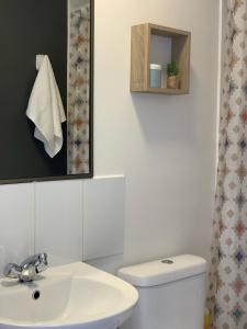 a bathroom with a white toilet and a sink at Caldera Apartment in Caldera