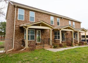 a brick house with a front porch and grass at Amazing ATL downtown houses - minutes walk to bars, food and transport! in Atlanta
