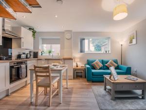 a kitchen and living room with a blue couch and a table at Ay Come Inn in York