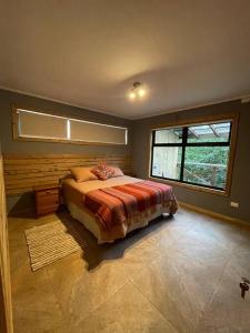 um quarto com uma cama e uma janela em Casa Divisadero en la Patagonia em Coihaique