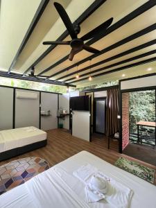 a room with two beds and a ceiling fan at Xscape Tambun in Ipoh