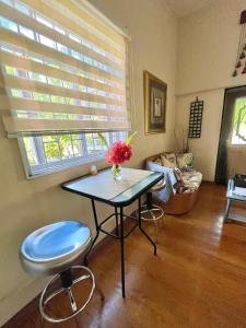 a living room with a table and a chair at Cozy 1 bedroom cottage w/pool in Bridgetown