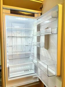 an empty refrigerator with its door open in a kitchen at Lovely 3 Bed Apartment Near QE Hospital Harborne Birmingham New in Birmingham