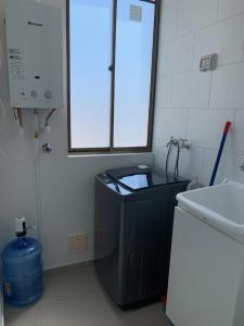 a bathroom with a sink and a washing machine at Caldera Apartment in Caldera