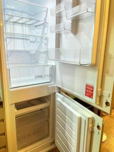 a refrigerator with its door open in a kitchen at Lovely 3 Bed Apartment Near QE Hospital Harborne Birmingham New in Birmingham