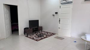 a white room with a tv and a door at Homestay Mama, Kota Bharu in Kota Bharu