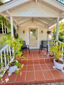 a porch with awning and potted plants at Cozy 1 bedroom cottage w/pool in Bridgetown