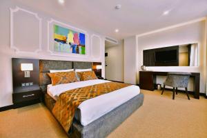 een slaapkamer met een groot bed en een flatscreen-tv bij Ghan Hotel in Istanbul
