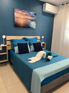 a bedroom with a blue bed with blue walls at Le Pavillon du trou d'eau in La Saline les Bains