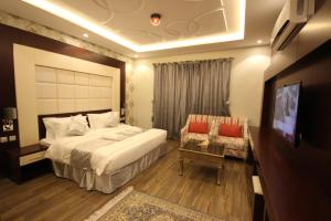 Pokój hotelowy z dużym łóżkiem i telewizorem w obiekcie Suit los w mieście Az̧ Z̧afīr