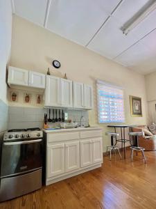 a kitchen with white cabinets and a stove at Cozy 1 bedroom cottage w/pool in Bridgetown