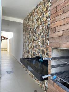 una cucina con lavandino e muro di mattoni di CASA K a Barra de São Miguel