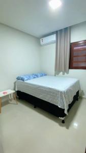 a bedroom with a bed in a room with a window at CASA K in Barra de São Miguel