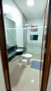 y baño con lavabo y aseo. en CASA K, en Barra de São Miguel