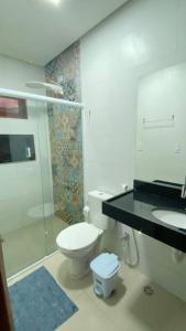 a bathroom with a toilet and a shower and a sink at CASA K in Barra de São Miguel