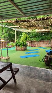 - une aire de jeux avec des tapis bleus sur un tapis vert dans l'établissement Tipsea Turtle Rooftop Hostel Gili Trawangan, à Gili Trawangan