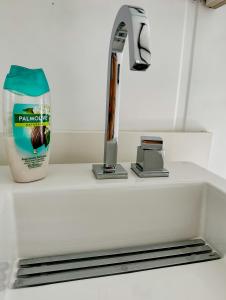 a kitchen sink with a faucet and a bottle of bathroom cleaner at Container com clima de montanha! in Siderópolis