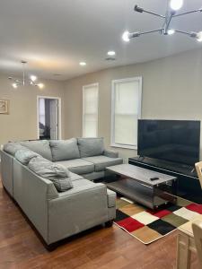 uma sala de estar com um sofá e uma televisão de ecrã plano em Z & Z APARTMENT 3 em Newark