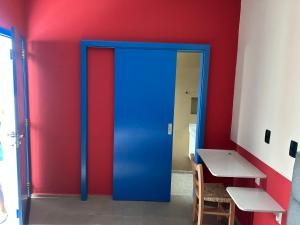 a blue door in a room with a table at Pequena Mykonos in Penha