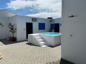 a house with a swimming pool in a courtyard at Pequena Mykonos in Penha