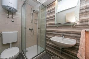 ein Badezimmer mit Waschbecken, Toilette und Dusche in der Unterkunft Apartments by the sea Tucepi, Makarska - 19857 in Tučepi + 26 Fotos
