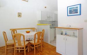 eine kleine Küche mit einem Tisch und Stühlen in einem Zimmer in der Unterkunft Apartments by the sea Brna, Korcula - 20827 in Smokvica