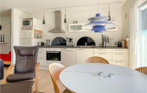 a kitchen with a white table and a dining room at Awesome Apartment In Allinge in Allinge