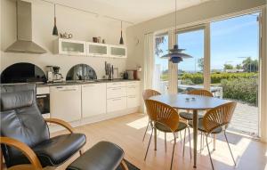 a kitchen and dining room with a table and chairs at Awesome Apartment In Allinge in Allinge