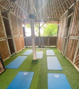 een kamer met groene vloeren en een paal erin bij Tipsea Turtle Gili Air in Gili Air