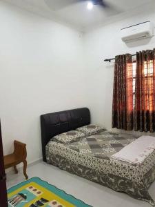 um quarto com uma cama, uma janela e um tapete em Villa Humaira Homestay - Cozy House for you em Pantai Cenang